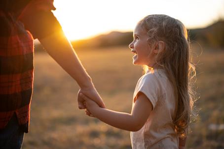 child holding adult's hand